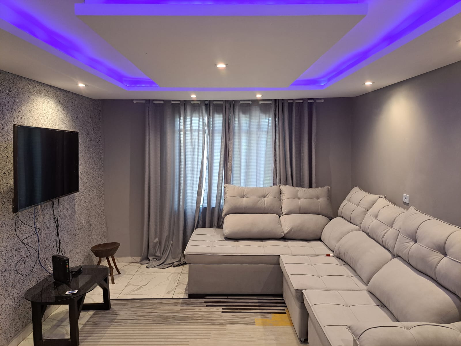 Sala de estar com sofá e sanca de drywall iluminada